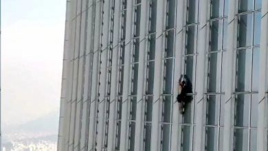 A climber risks his life to climb a giant tower without ropes